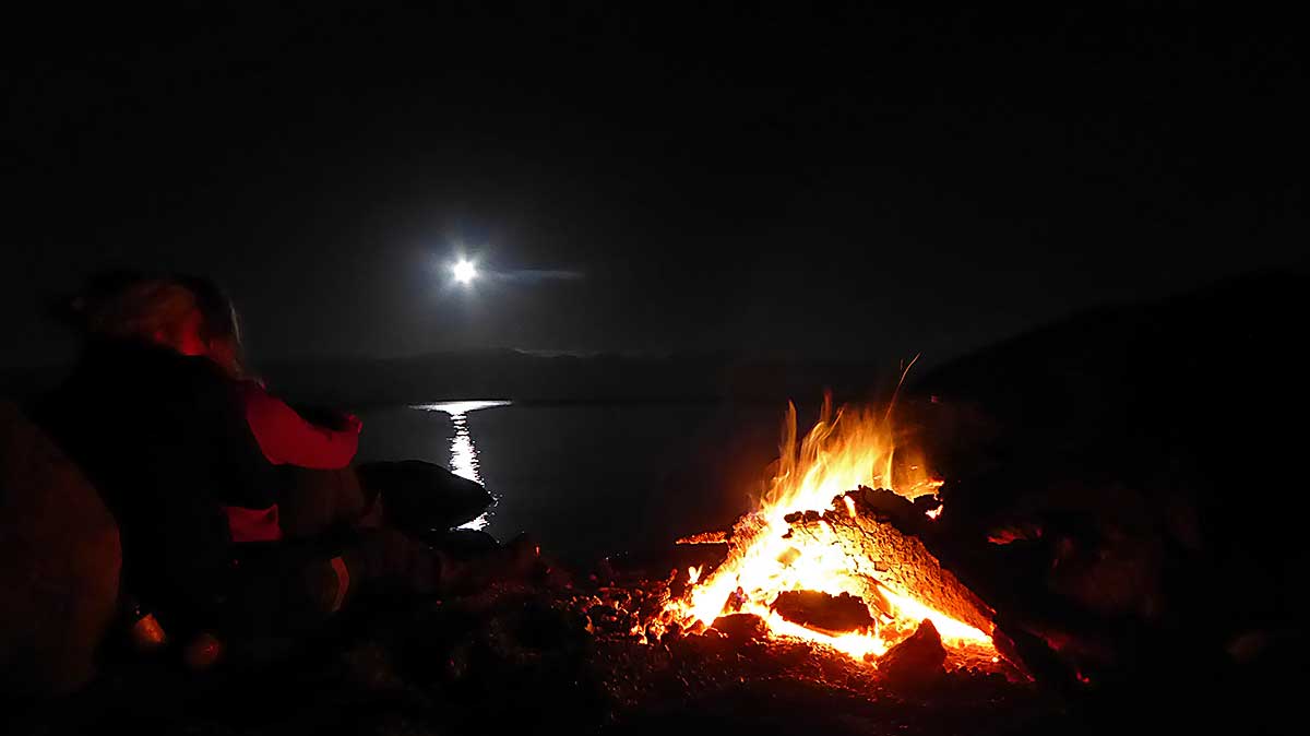 Abendliches Lagerfeuer am Villarrica See bei aufgehendem Mond 